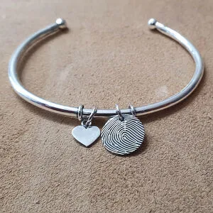 Drie gouden armbanden met platte schakels op zwart fluweel